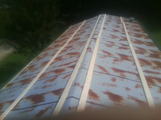 Rusted metal roof panels with new wood purlins before replacement — Storm Damage Roof Repair in Bentonia by Roofing Brothers