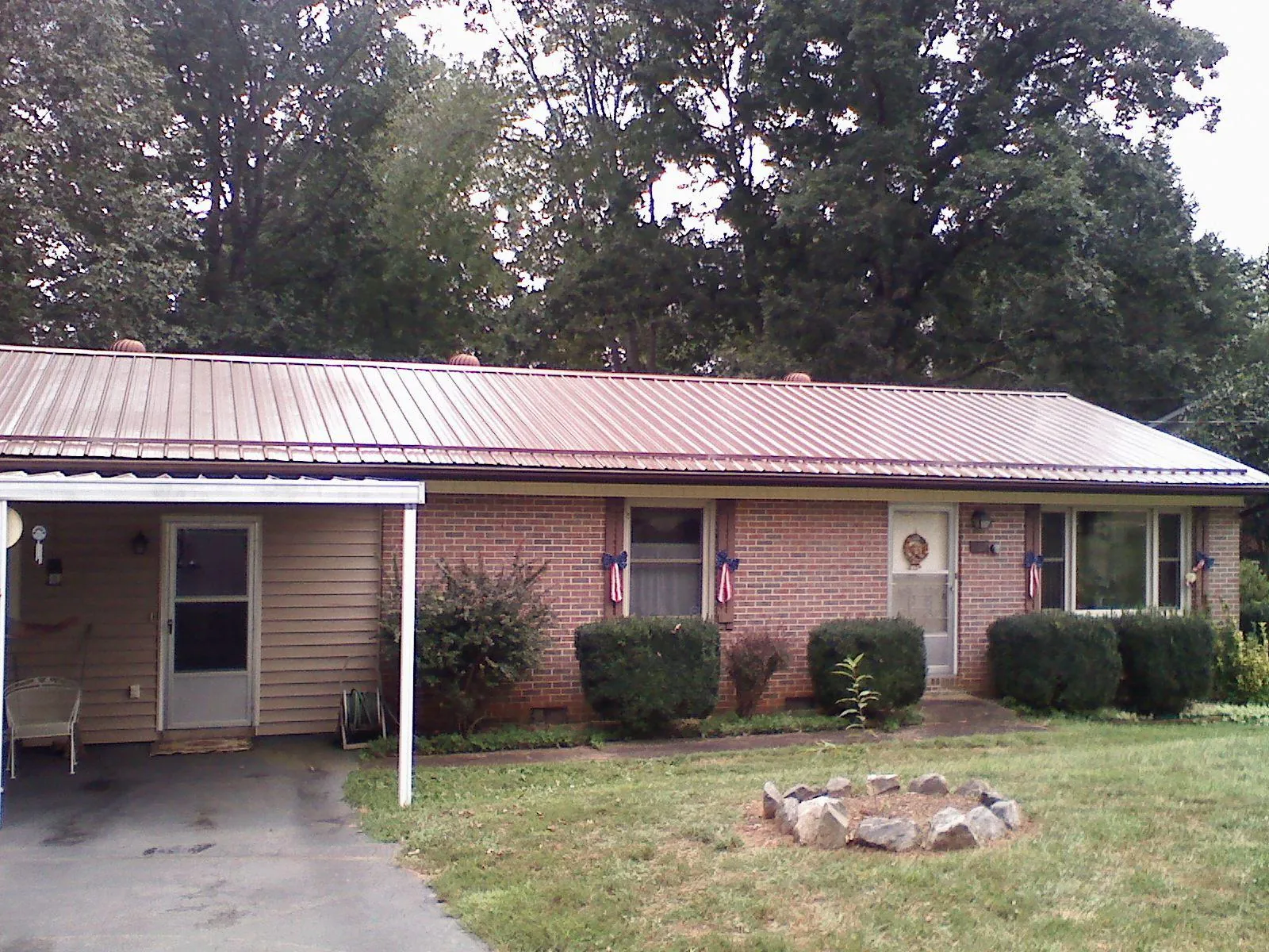 Bronze metal roof and carport on a brick ranch home — Roof Repair work by our crew in Bentonia